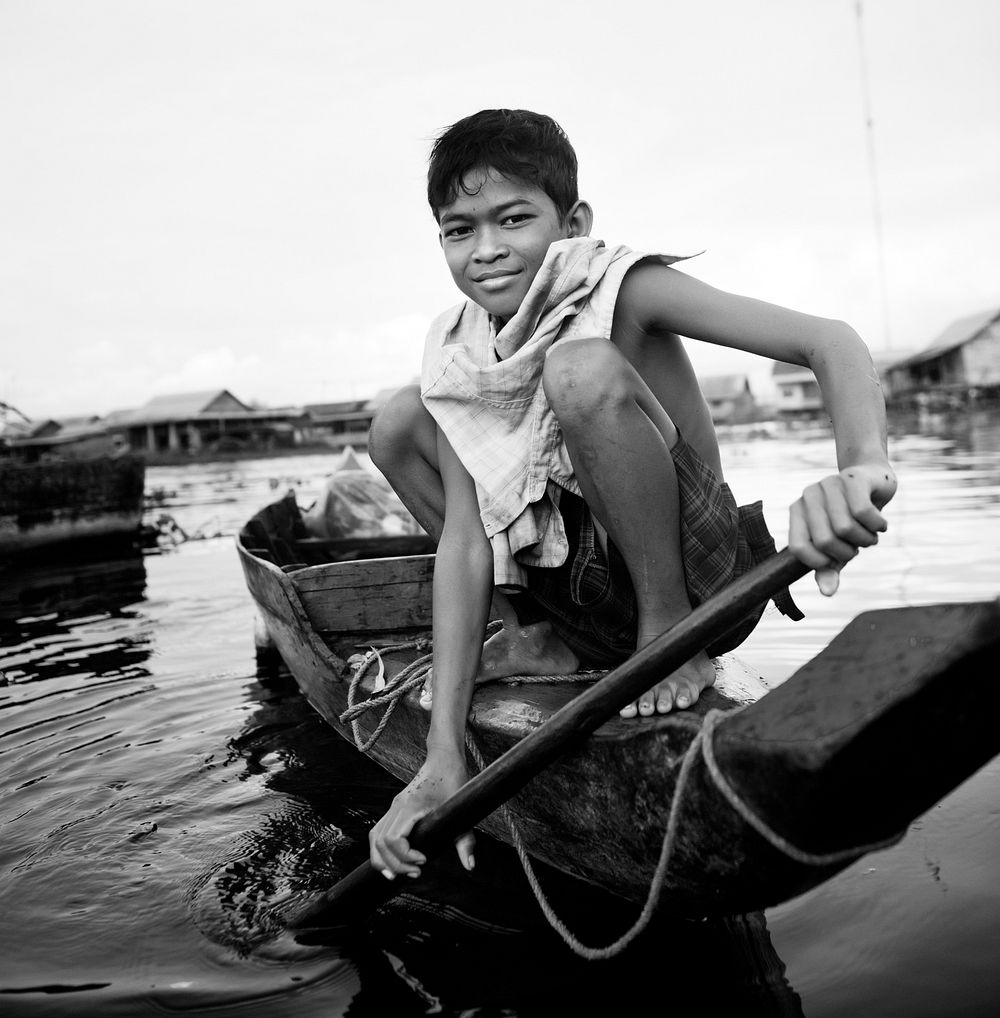 Boy traveling by boat in floating village.