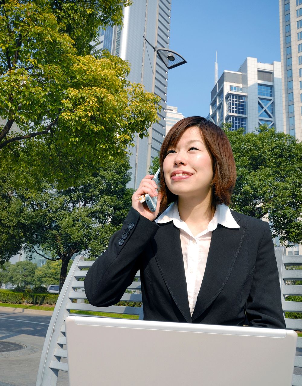 Asian businesswoman working by skyscrapers.