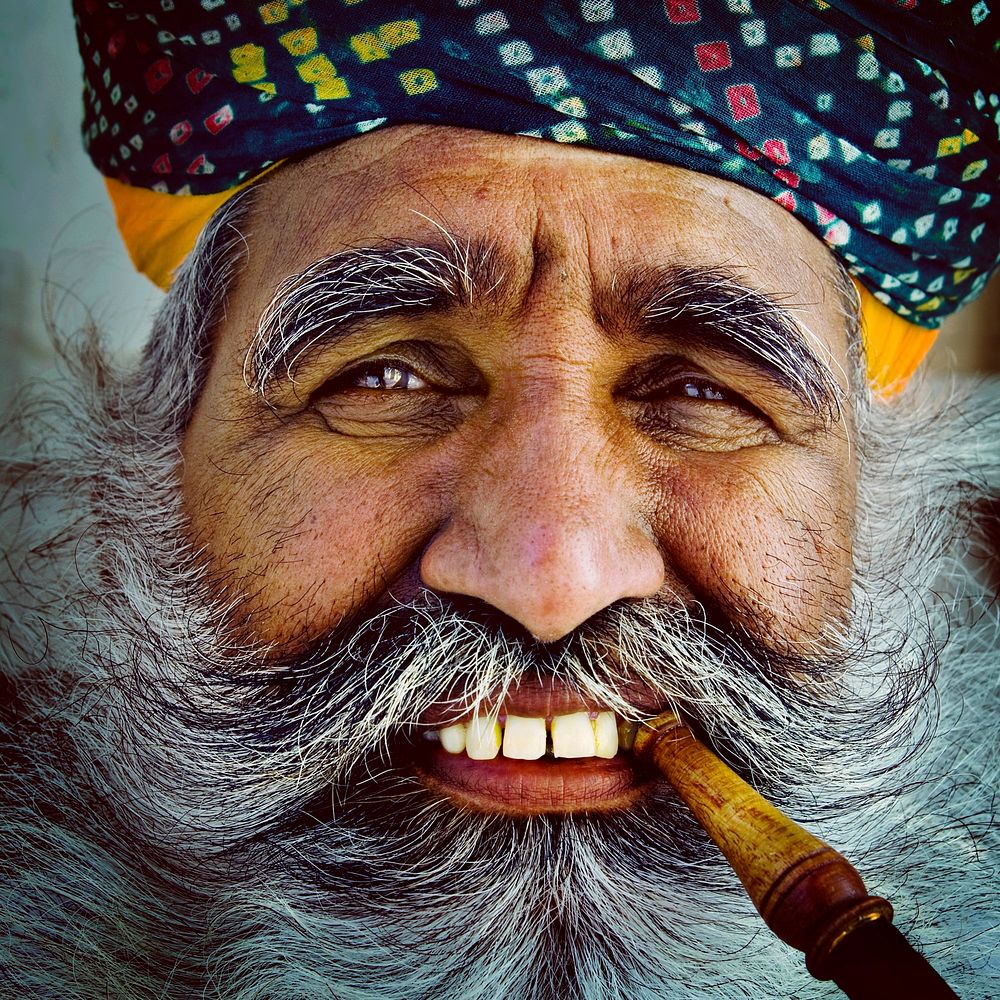 Bearded Indian man smoking a pipe