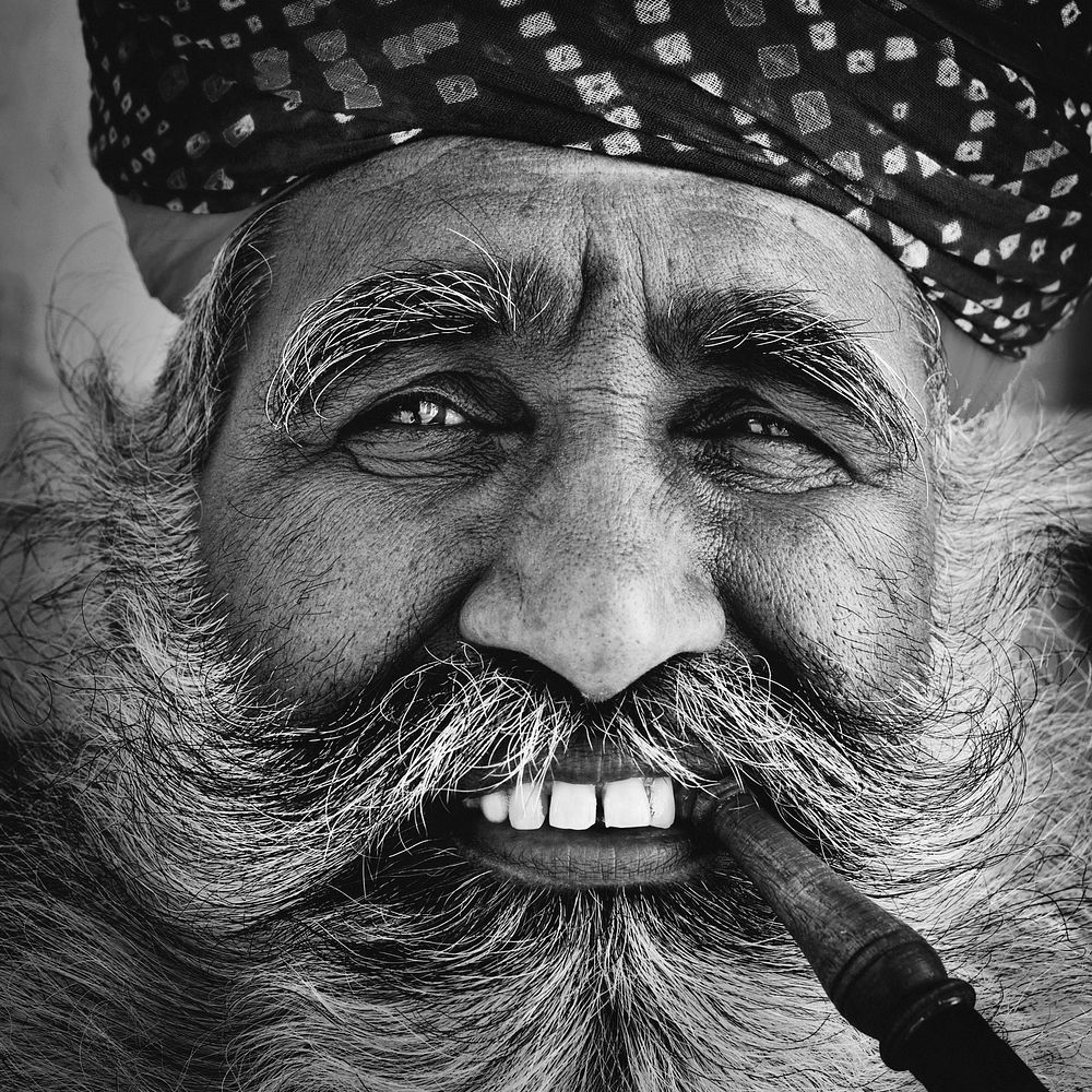 Bearded Indian man smoking a pipe