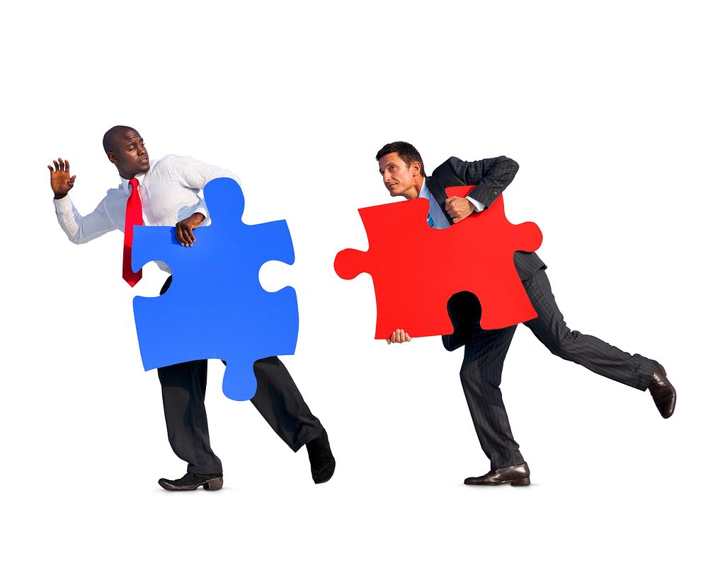 Two Businessmen Holding Jigsaw Puzzles In A White Background