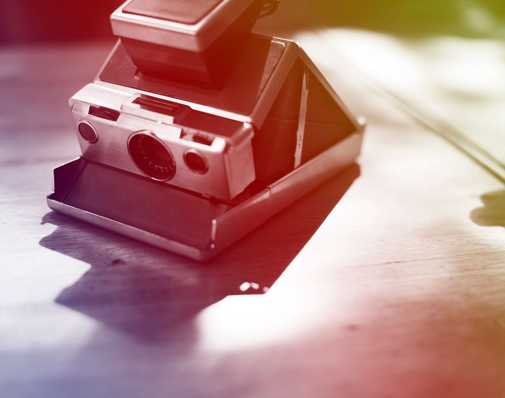 Vintage retro instant photo camera on the wooden table