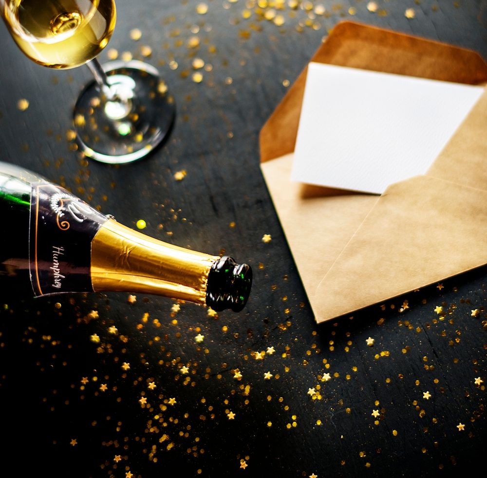 Celebration with champagne and card on black table