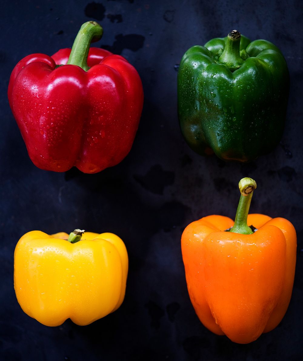 Closeup of various bell peppers on black background