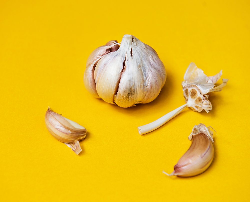 Garlic cloves on yellow background
