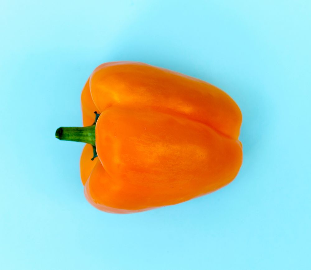 Aerial view of fresh sweet peppers on blue background