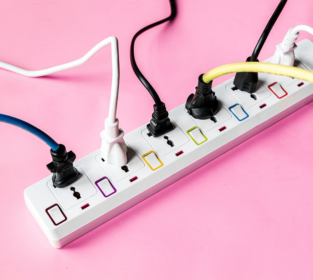 Fulled electrics power supply plug on pink background