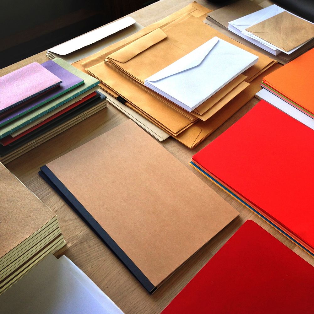 Closeup aerial view of notepads and envelopes letters on wooden table