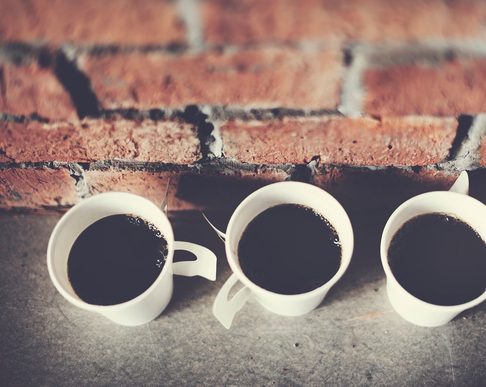 Closeup of coffee cups with brick wall background