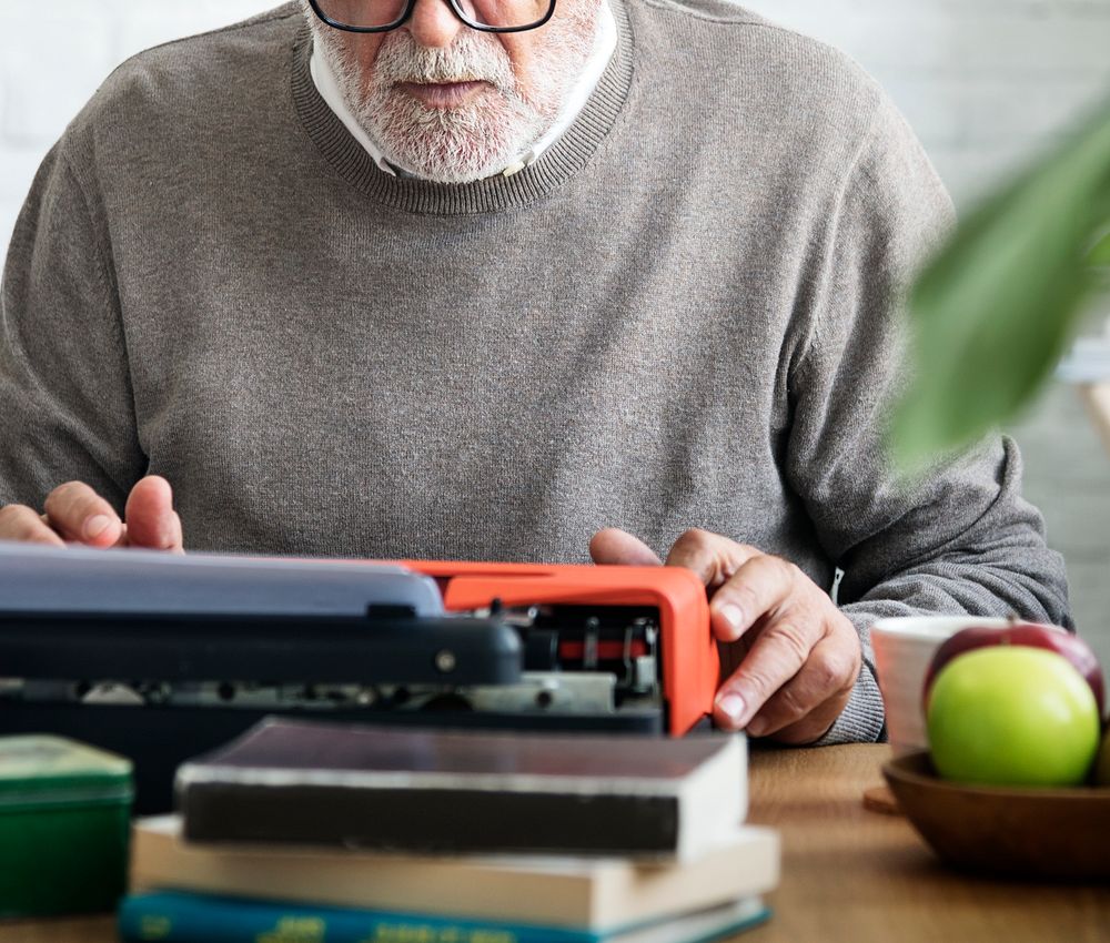 Old man typing on a typewriter