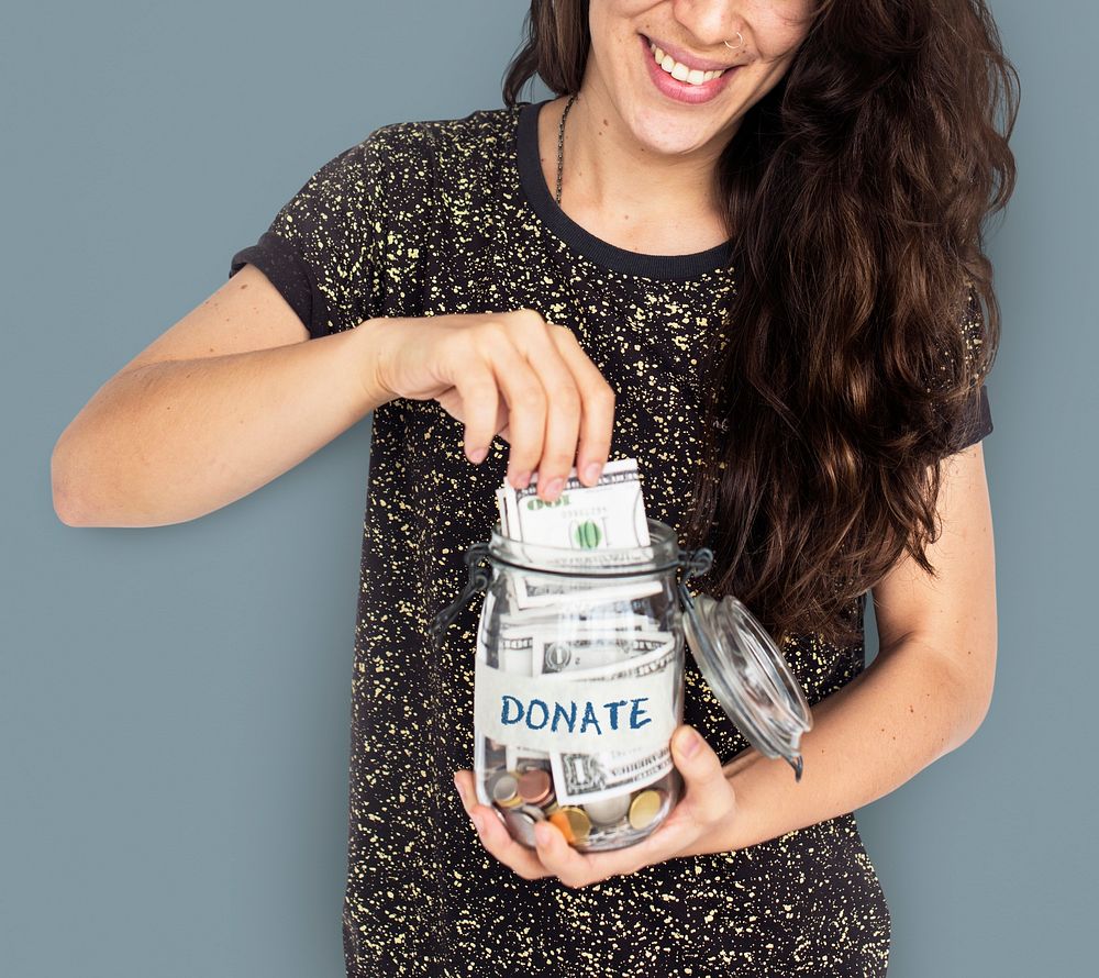 Brunette woman donating in a jar
