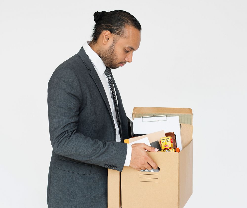 Studio portrait of a sad businessman holding a box of his office stuff