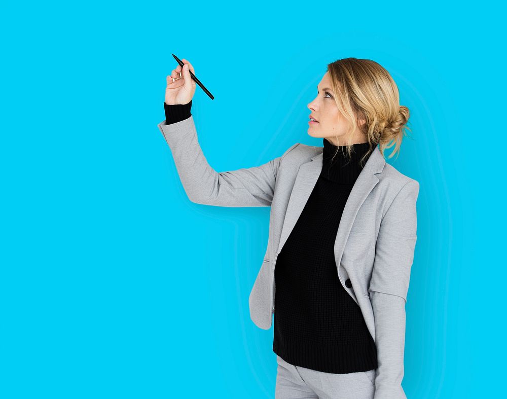 Studio portrait of a business woman writing on air with a pen