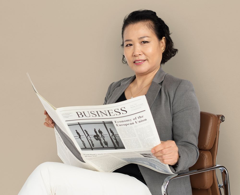 Asian Business Woman Reading Newspaper