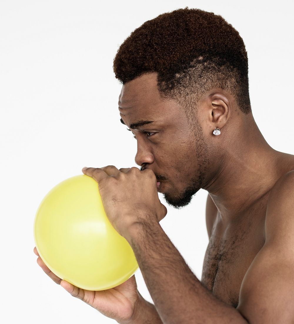 Young black guy blowing a balloon
