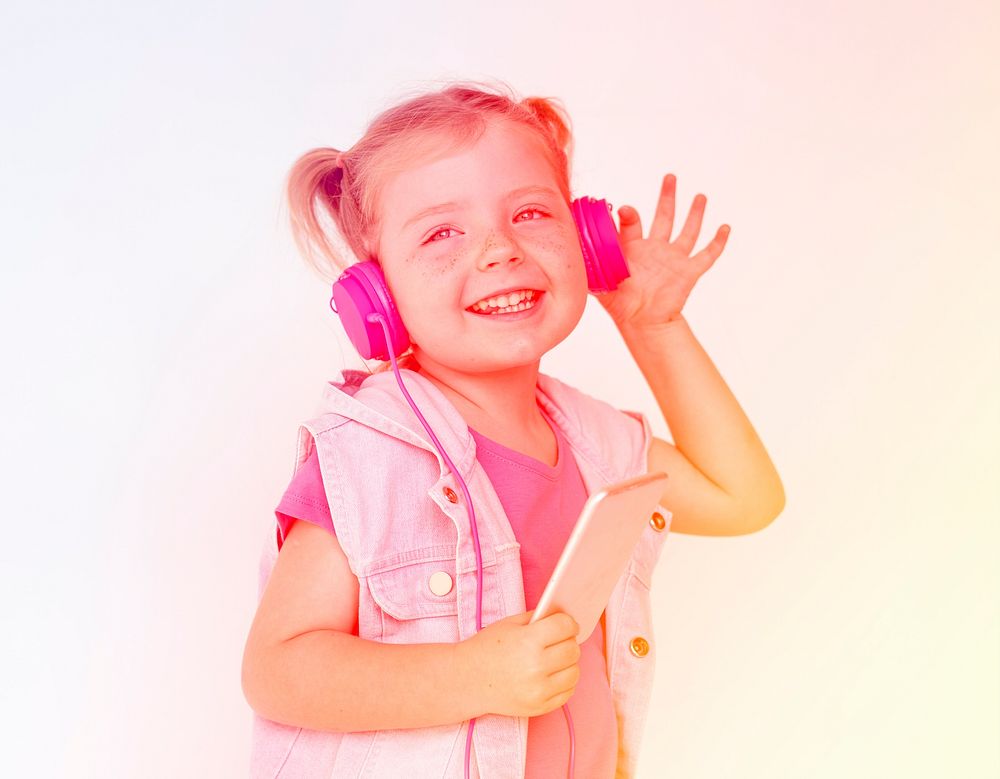 Little girl listening music with headphone and smiling