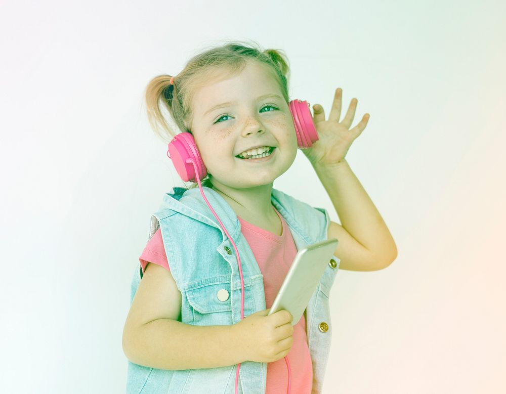 Little girl listening music with headphone and smiling