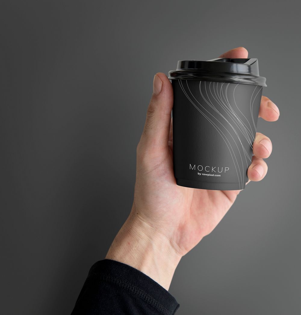 Human hand holding a mockup coffee cup