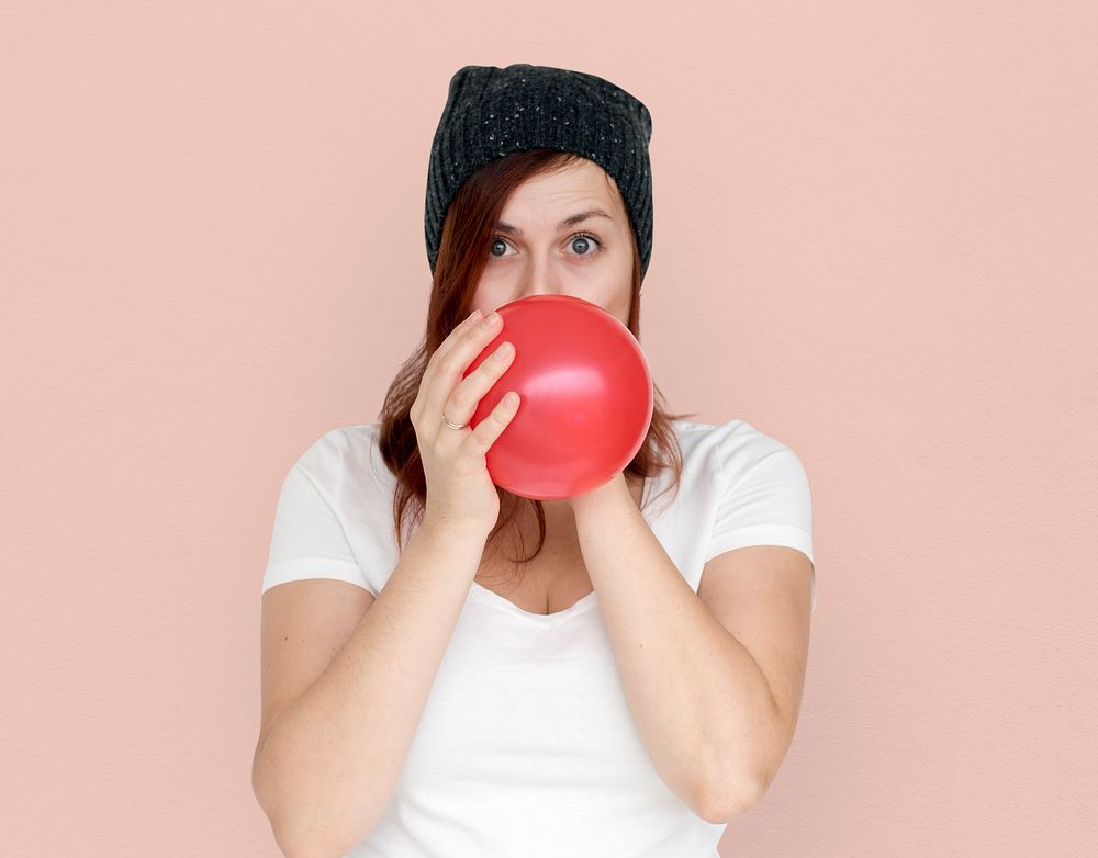 Woman Blowing Balloon Playful Studio Portrait