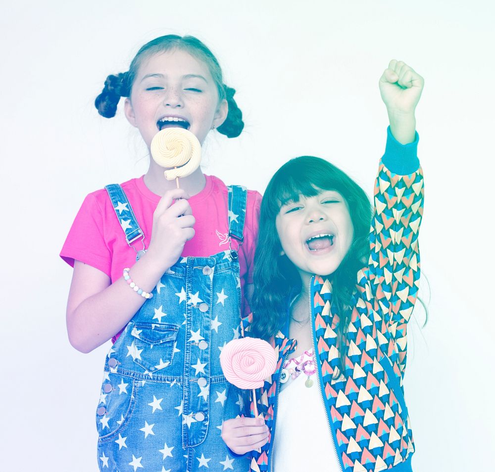 Children sisters happiness eating lillipop smilinng