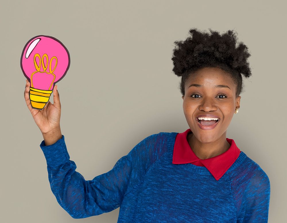 African Descent Woman Smiling and Holding Light Bulb
