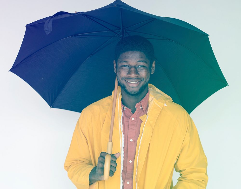 African man with umbrella and raincoat on white background