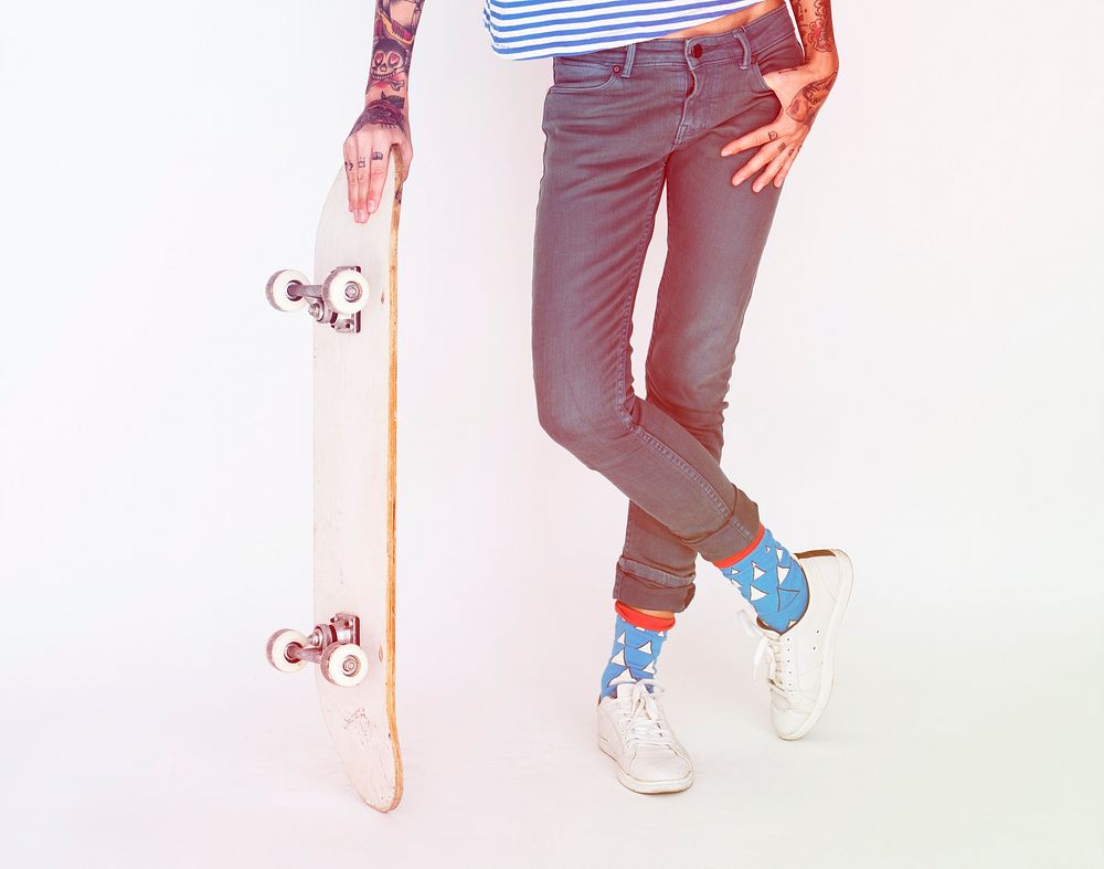 Woman standing and posing for picture with skateboard