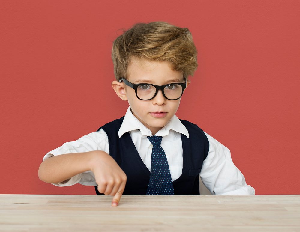 A Caucasian Boy Pointing Wooden Table Background Studio Portrait