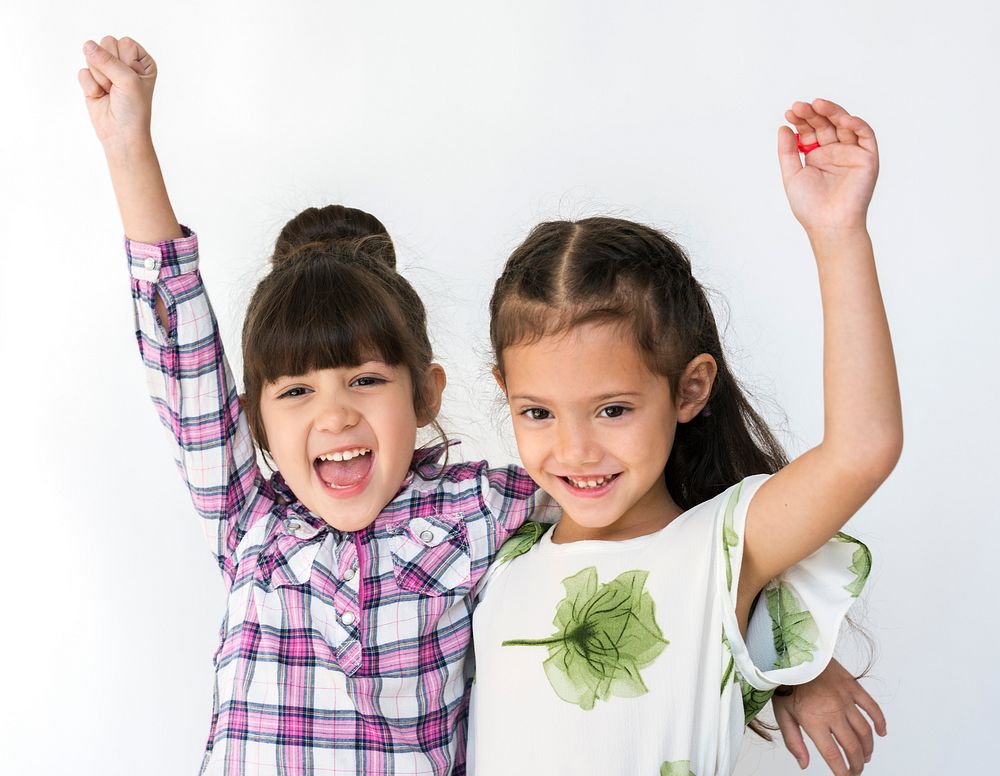 Little cute and adorable girls smiling together studio portrait