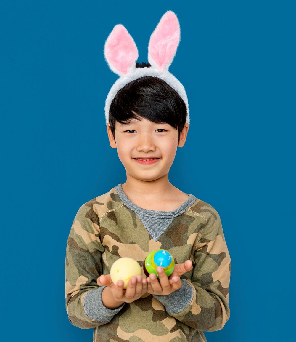 Kid with a bunny hairband holding eggs
