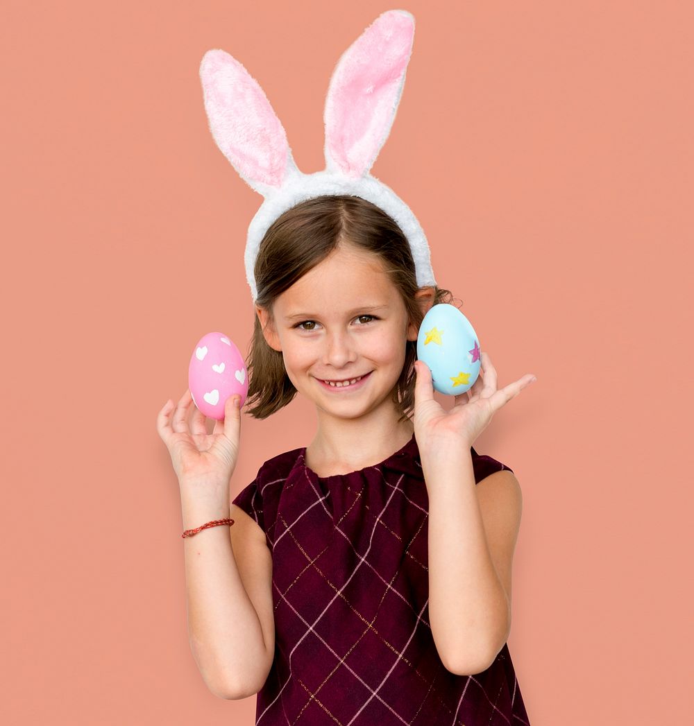 Kid with a bunny hairband holding eggs