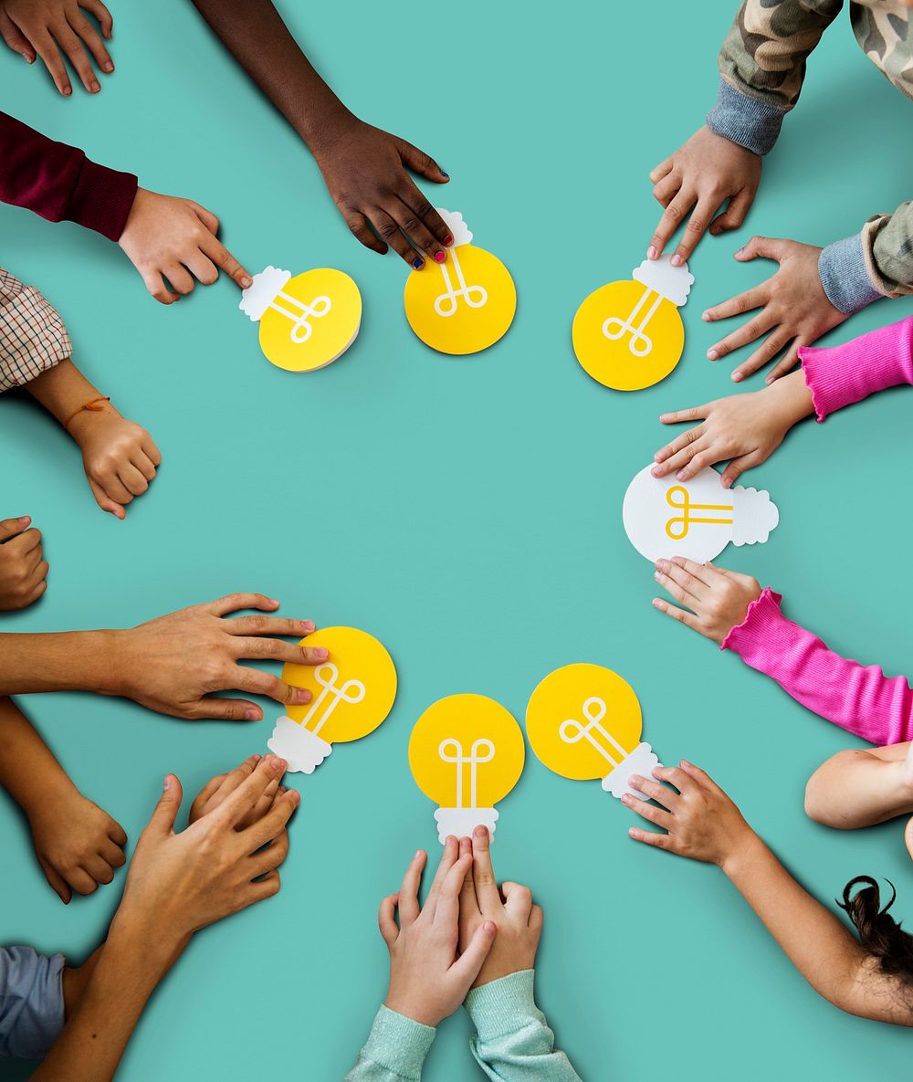 Aerial group of kids hands holding light bulb icon