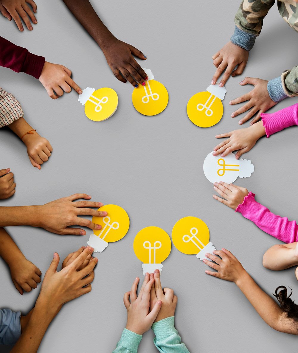 Aerial group of kids hands holding light bulb icon