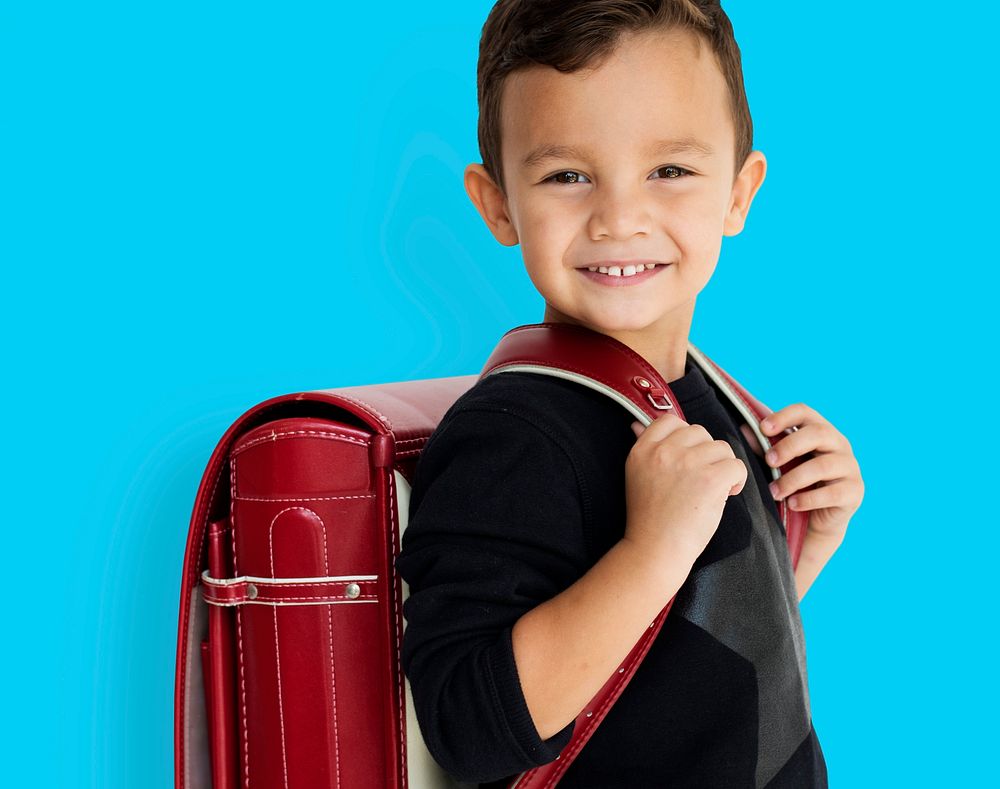 Young asian kid student with a backpack studio portrait