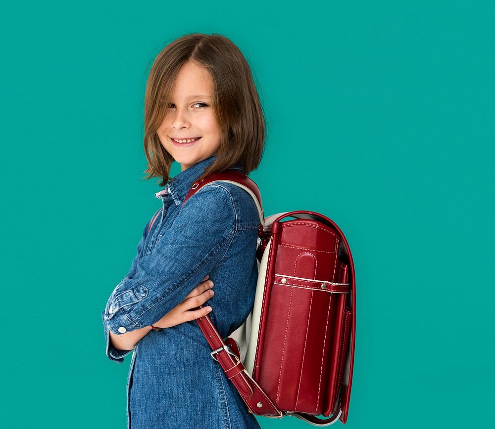 A girl with backpack is smiling.