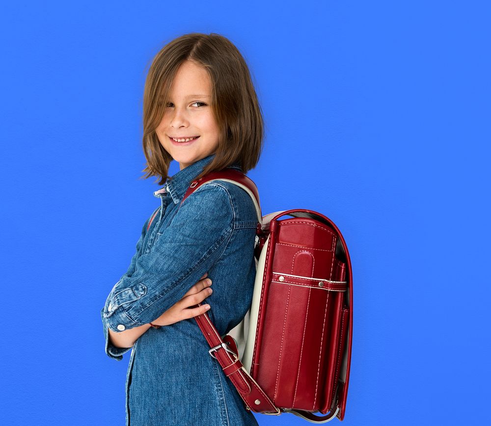 A girl with backpack is smiling.