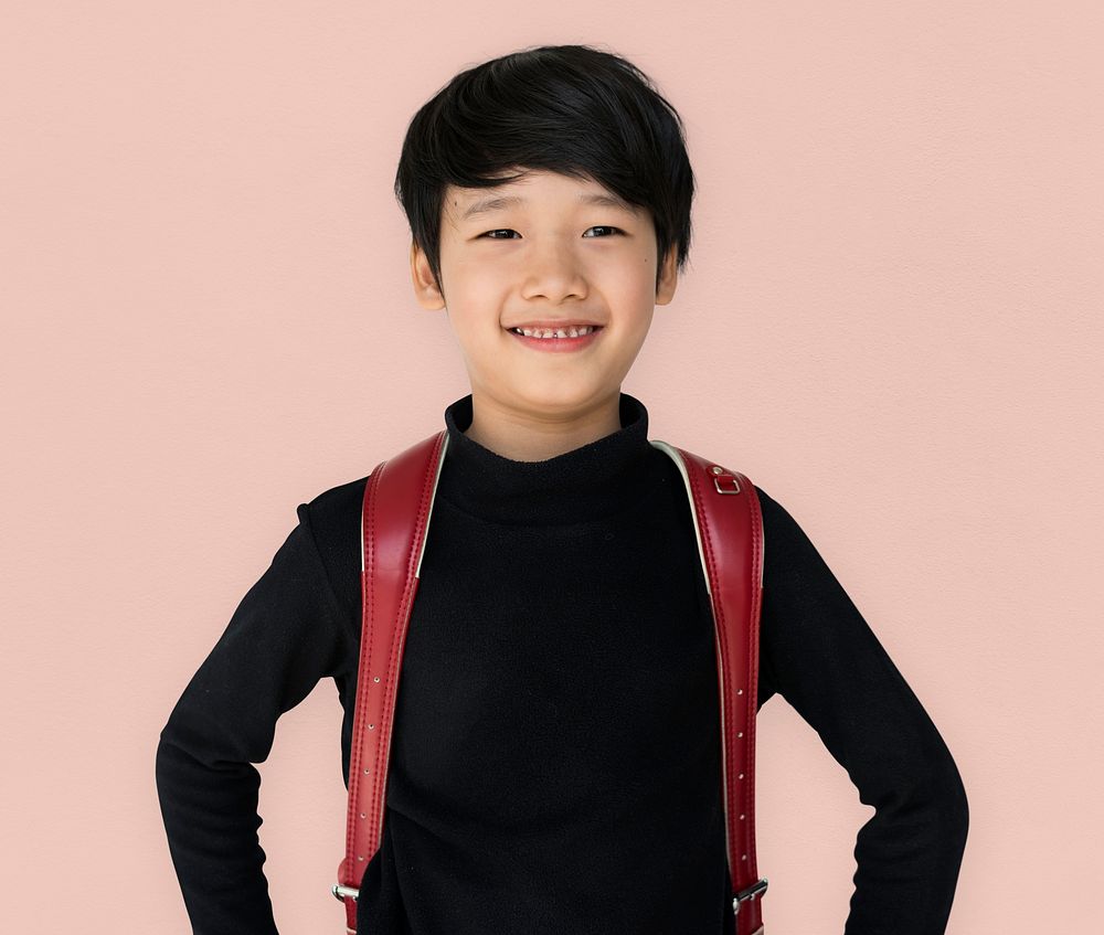 Asian ethnicity boy with backpack is smiling