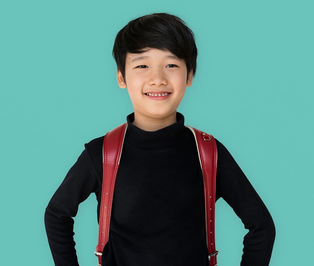 Asian ethnicity boy with backpack is smiling