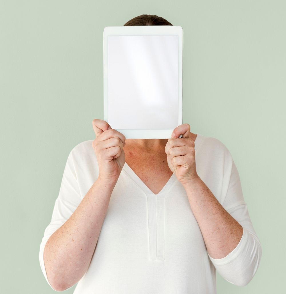 Woman holding blank digital tablet cover face studio portrait