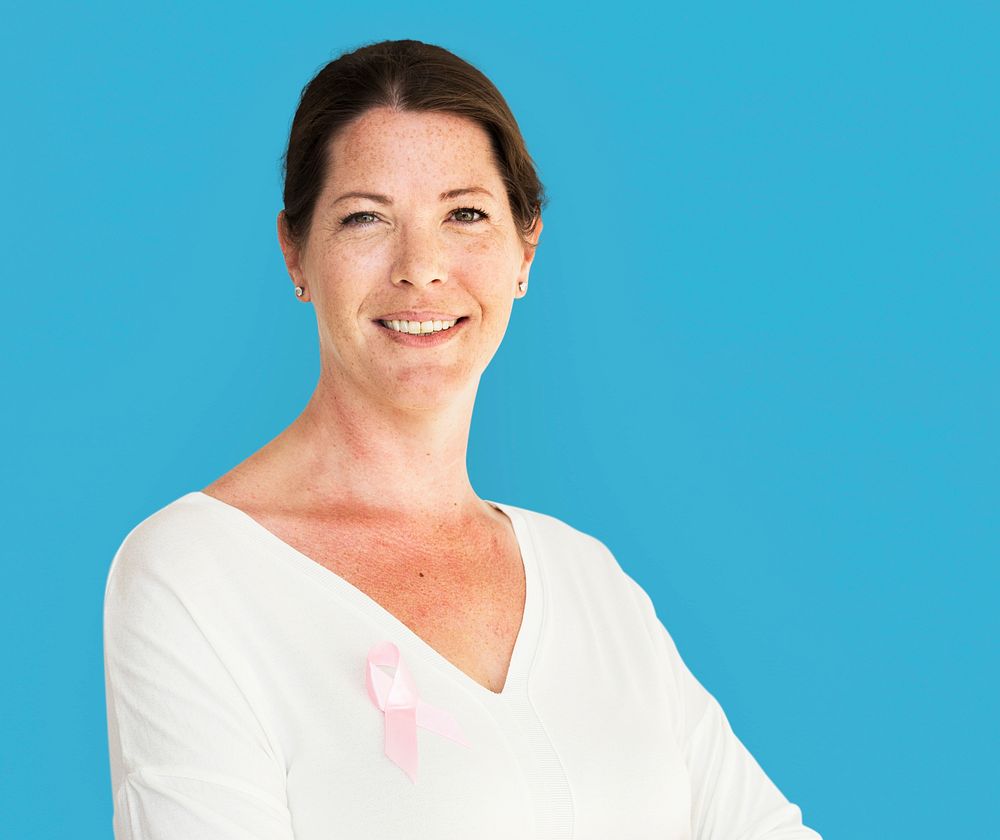 Woman with pink ribbon for breast cancer awareness charity studio portrait