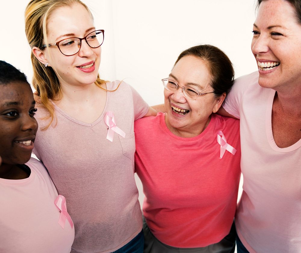 Group of girlfriends with pink ribbon for breast cancer awareness