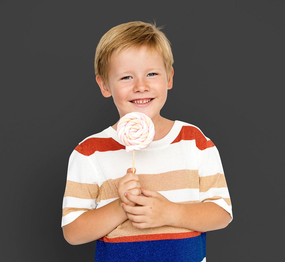 Little boy smiling and holding sweet candy lollipop