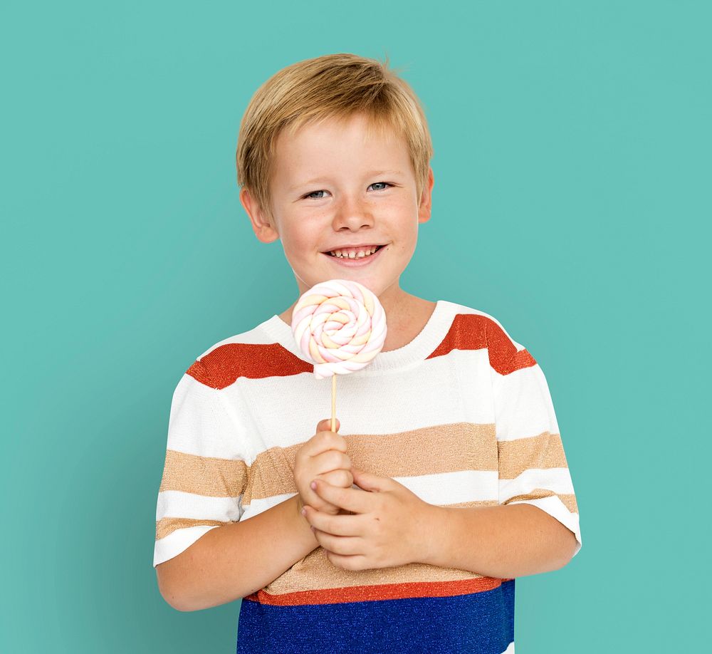 Little boy smiling and holding sweet candy lollipop