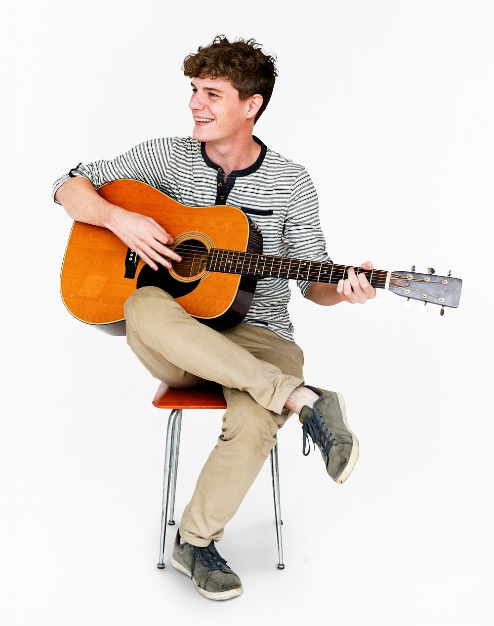 Young Adult Man Sitting Playing Guitar Studio Portrait