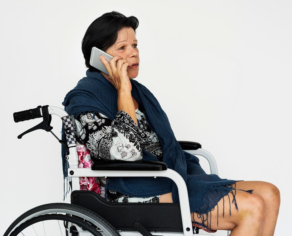Senior adult woman using mobile phone on wheelchair