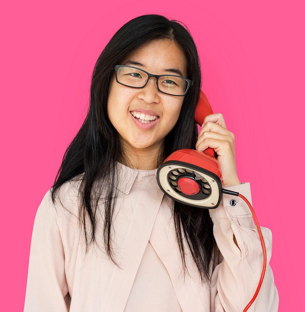 Asian girl talking by phone studio portrait