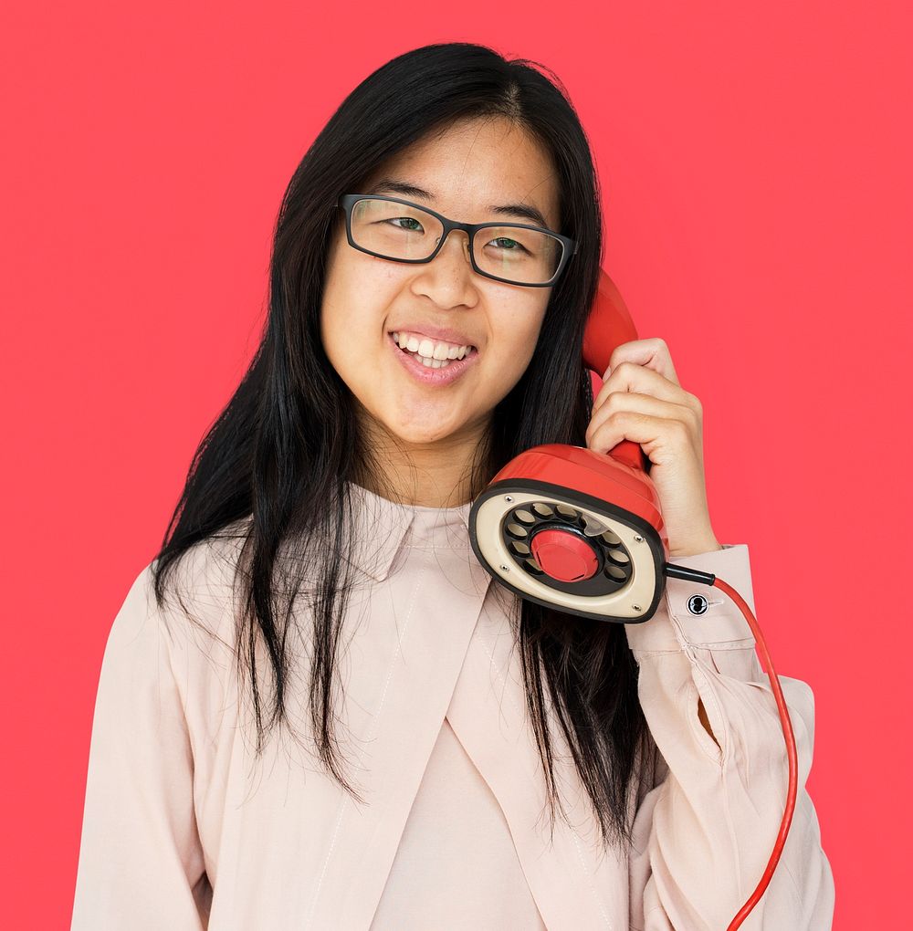 Asian girl talking by phone studio portrait