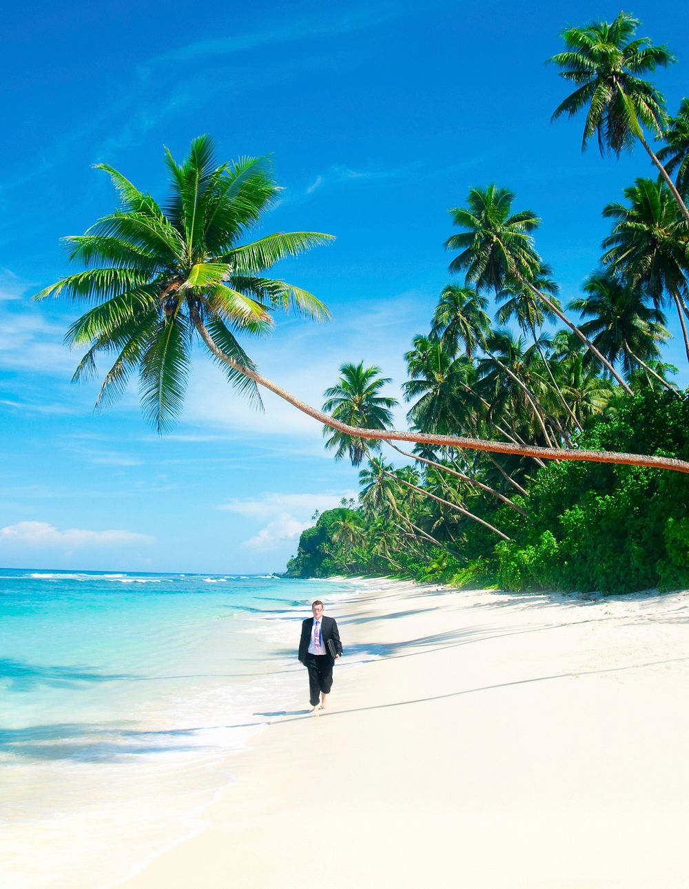 Businessman walking down a tropical beach