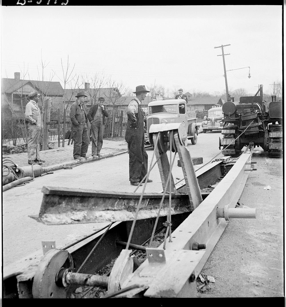 Buried trolley tracks salvaged to aid war program. Removing abandoned trolley tracks to provide much needed scrap for Uncle…