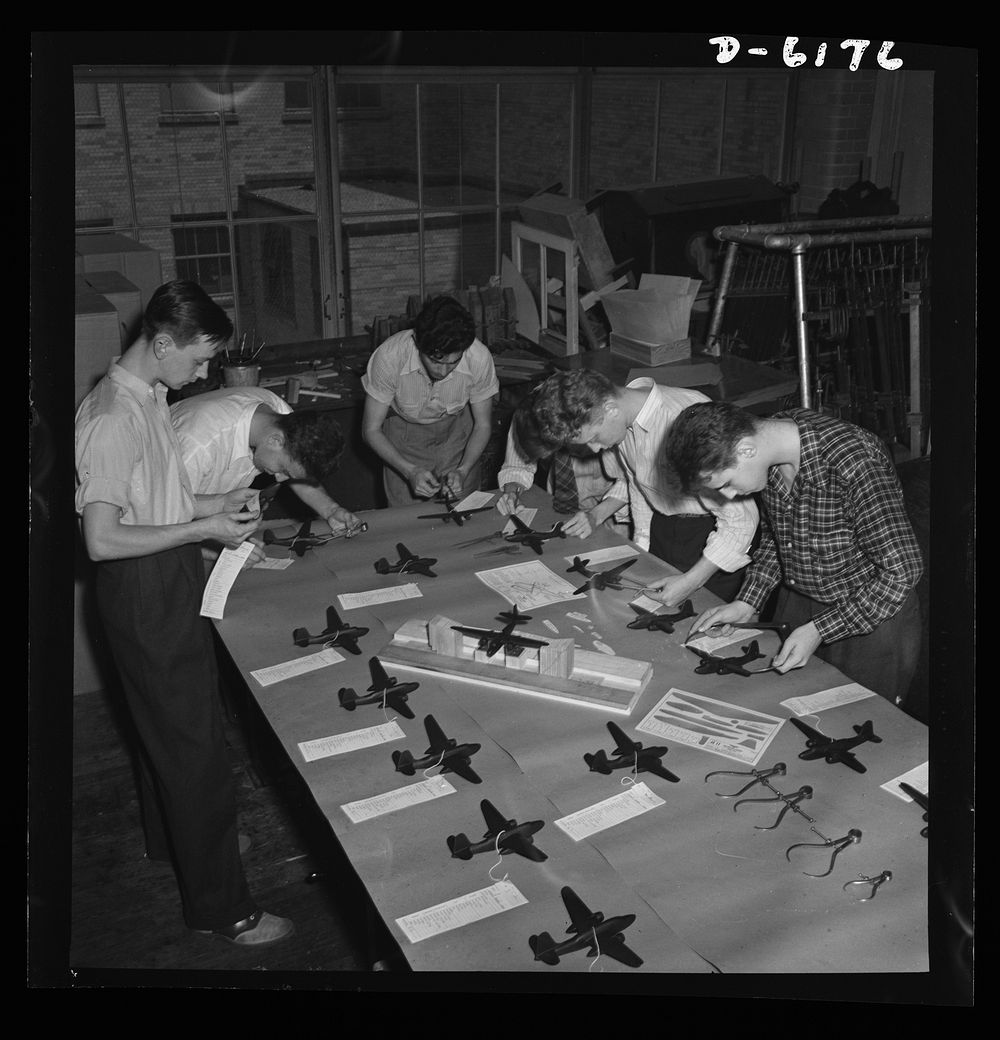 Training high school boys to identify planes. Student's test model planes for accuracy of specification, in a basic aviation…